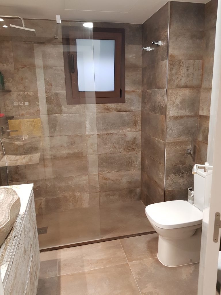 Zona de ducha de un baño reformado por Vizuete